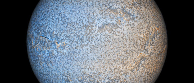 A high-resolution close-up image of the Sun, highlighting its textured surface covered in swirling patterns and structures. The overall color palette is primarily blue and white with touches of orange and gray, emphasizing the Sun's dynamic activity. The background is black.